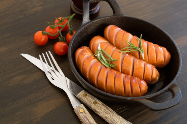 istock Fried sausages on a cast iron pan. on the board 1130537121
