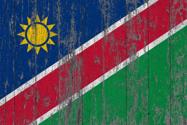 Flag of Namibia painted on worn out wooden texture background.