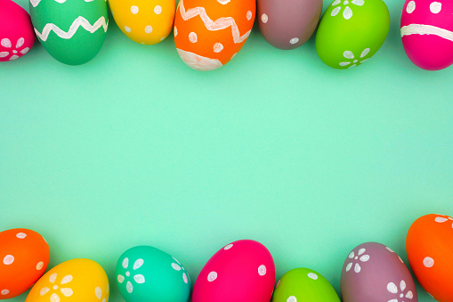 Colorful Easter Egg double border against a turquoise green background. Top view with copy space.
