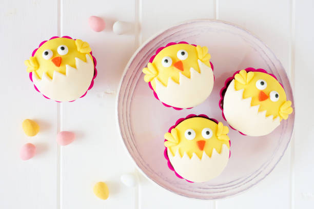 Hatching spring chick cupcakes on a white plate against white wood