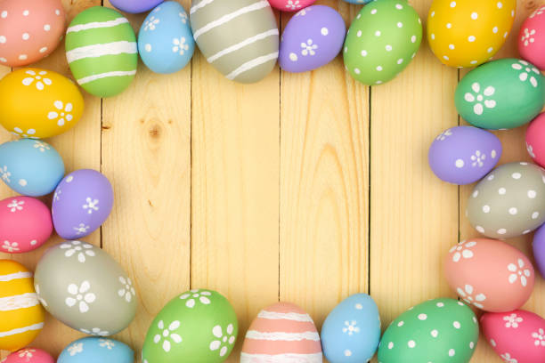istock Colorful pastel Easter Egg frame against a natural wood background 1130540464