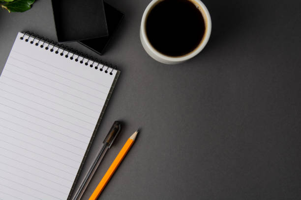 istock Creative flat lay of workspace desk. Top view office desk with notebooks and coffee cup on grey background. Top view with copy space. Minimalistic work space. 1130541352