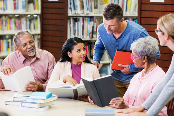 istock Diverse group of adult students conversing in library 1130541482