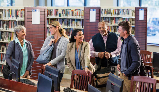 istock Multi-ethnic group of adults standing in library 1130543019
