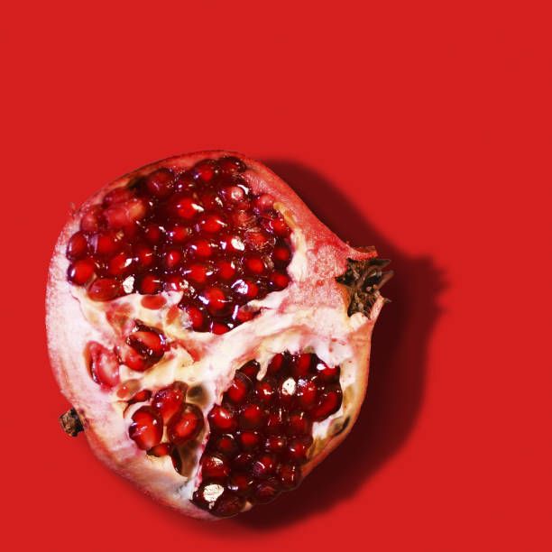 istock Ripe juicy pomegranate fruit isolated on red background. 1130543772
