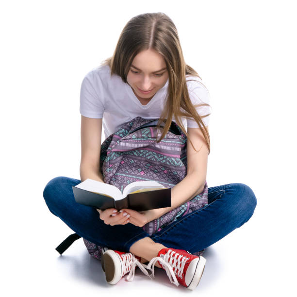 istock Woman sitting and reading book backpack 1130543840