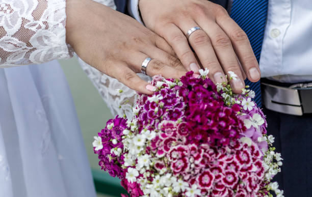istock Wedding rings on bride and groom hands 1130543849