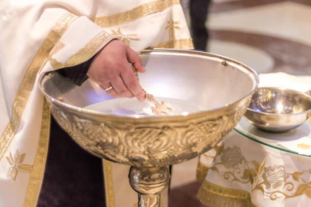 istock Priest holding the cross over the Holy water 1130543928