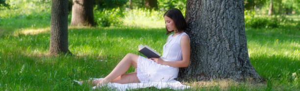 istock Beautiful woman reading book in the forest 1130544524