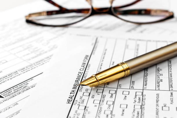 istock Pen with eyeglasses on health insurance claim form. 1130544892