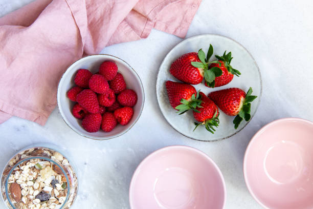 istock granola with bowl raspberries, strawberry, blueberry on marble textured background 1130545149
