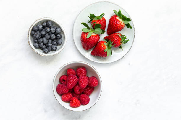 istock Fresh berries in bowl on marble background 1130545397