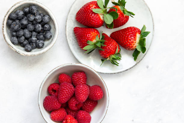 istock Fresh berries in bowl on marble background 1130545428