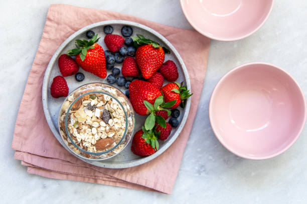 mixed berries in conrete plate on marble background with empty plate and copy space - vitality food food and drink berry fruit imagens e fotografias de stock