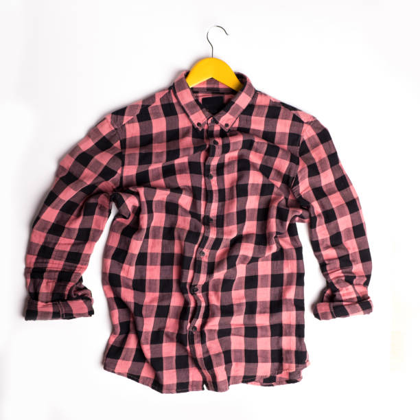 istock Plaid pink shirt on yellow hangers on a white background. 1130546567