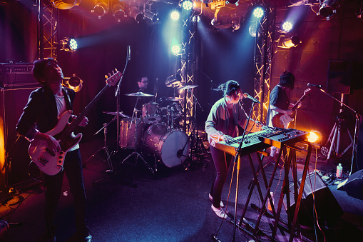 A rock band plays a live performance in a small club in Tokyo, Japan.