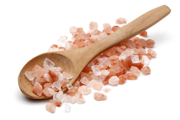 Himalayan salt in wooden spoon isolated on white