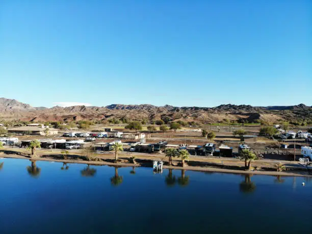 Blue skies and blue water with reflections in desert country of Arizona - RVs parked along riverside.