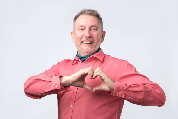 istock Senior man, holding hands in heart gesture and smiling 1130552260