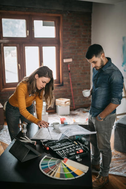 istock Couple looking at renovation plans at their new home 1130558277
