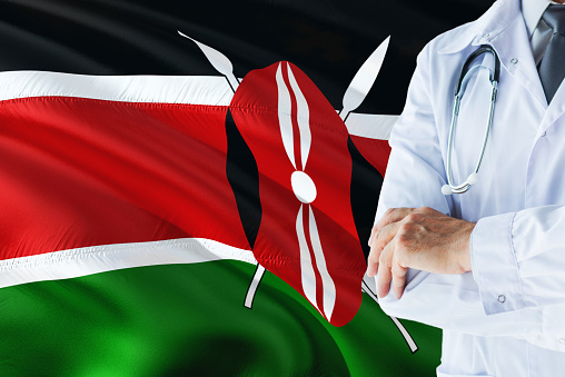 Kenyan Doctor standing with stethoscope on Kenya flag background. National healthcare system concept, medical theme.