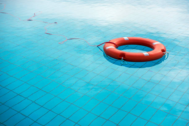 orange color life preservers floating in swimming pool in greece - life jacket isolated red safety imagens e fotografias de stock