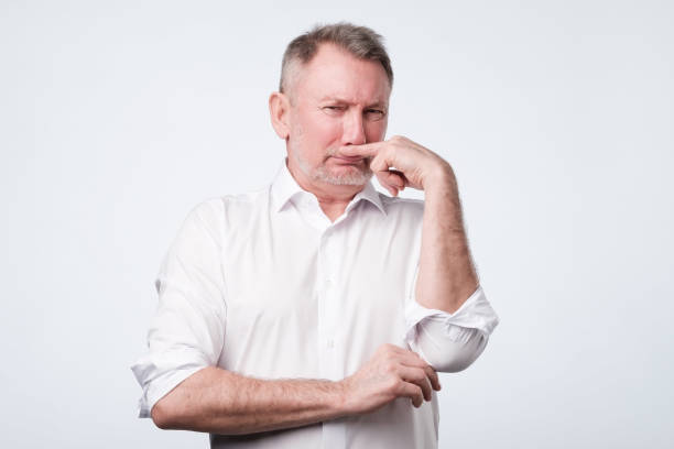 istock Man pinches nose with finger looks with disgust something stinks bad smell 1130563214