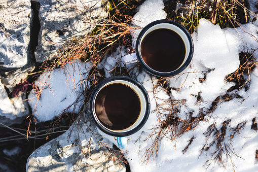 Two coffee cups on melting snow