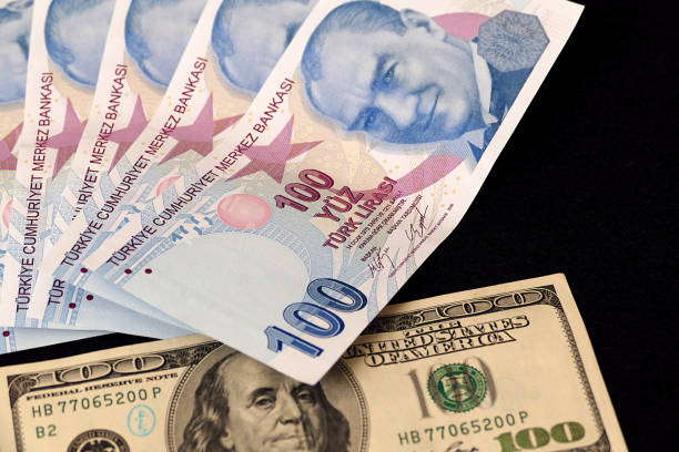 istock 100 Turkish Lira and 100 USD banknote, black background, side by side, 1130564044