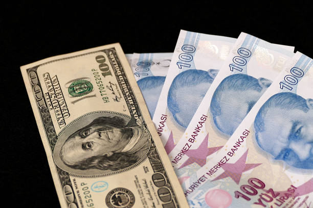 istock 100 Turkish Lira and 100 USD banknote, black background, side by side, 1130564061