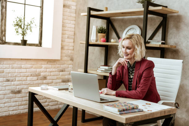 istock Pleasant good-looking lady touching her chin during conversation 1130564322