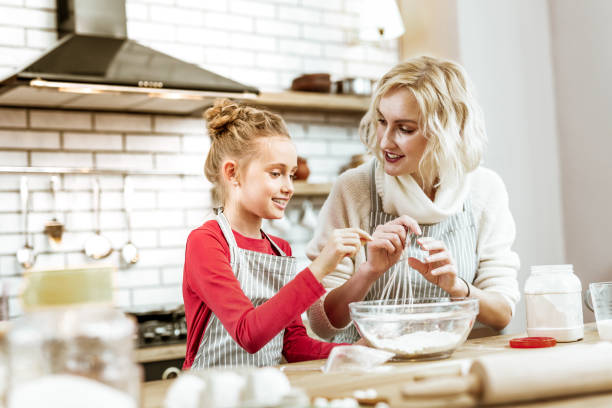 istock Smiling little kid in red dress asking about baking process 1130564478