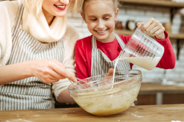 istock Happy joyful little kid adding milk from measuring cup 1130564520