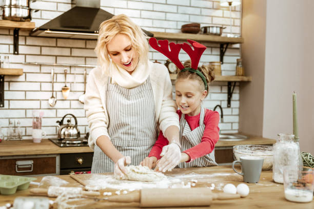istock Attentive curious kid disturbing her smiling mother while preparing 1130564540