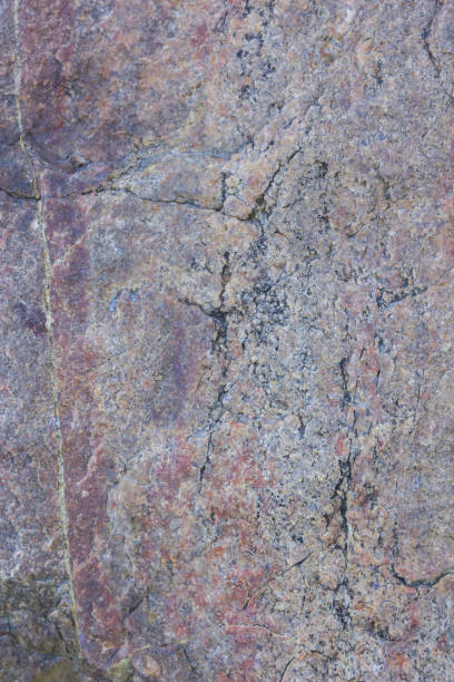 istock Texture of granite close up. Granite rock with reddish color. Background from solid stone. Pattern with natural material 1130564578