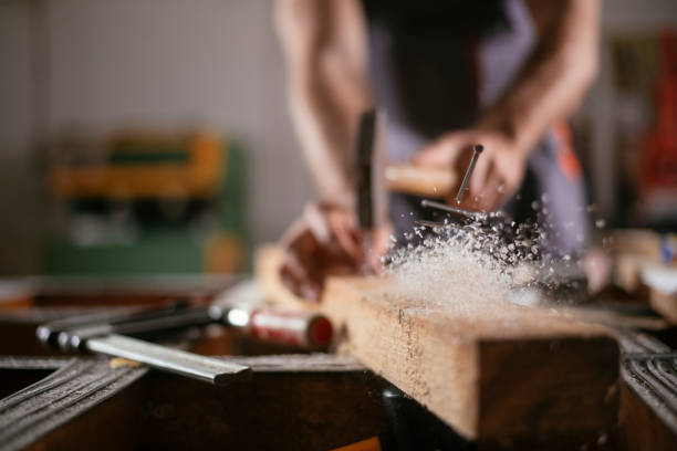 Close up of carpenter woodworking Close up of carpenter woodworking. Shallow DOF. Developed from RAW; retouched with special care and attention; Small amount of grain added for best final impression. 16 bit Adobe RGB color profile. hit the nail on the head stock pictures, royalty-free photos & images