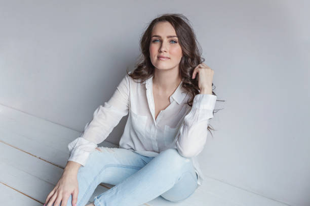 istock Girl in bright room sitting against white wall 1130567906