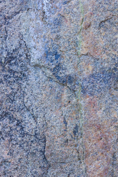 istock Granite texture close up. Granite rocks with porous surface. Background from solid stone. Pattern with natural material 1130569135