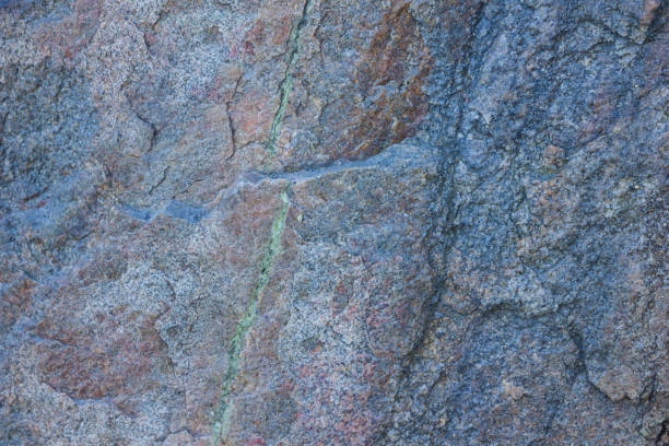 istock Granite texture close up. Granite rocks with porous surface. Background from solid stone. Pattern with natural material 1130569442