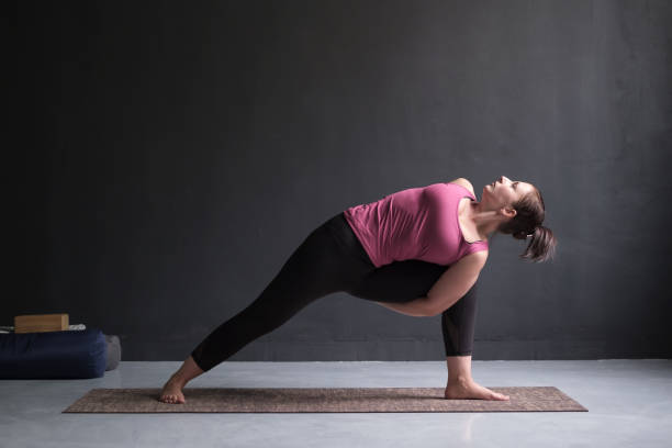 istock Woman practicing yoga Utthita parsvakonasana exercise, Extended Side Angle pose 1130570619