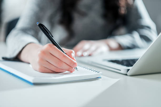 istock Young woman executive working with laptop and taking notes. 1130572699