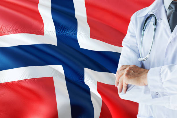 Norwegian Doctor standing with stethoscope on Norway flag background. National healthcare system concept, medical theme. médico noruego con estetoscopio sobre fondo de bandera de noruega. concepto de sistema nacional de salud, tema médico. médico noruego con estetoscopio sobre fondo de bandera de noruega. concepto de sistema nacional de salud, tema médico. doct noruego