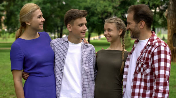 famille posant sur la caméra, passant du temps ensemble, l'assurance sociale, la stabilité - vacations women men stability photos et images de collection