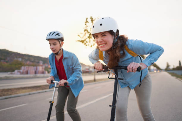 istock Mom and her boy racing with push scooters 1130577562