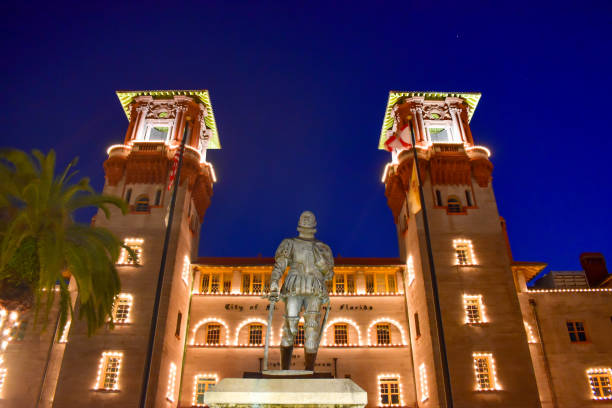 santo agostinho, flórida. 26 de janeiro de 2019. museu iluminado de lightner e estátua de henry flager no fundo azul da noite na costa histórica de florida. - southern california palm tree beverly hills california california - fotografias e filmes do acervo