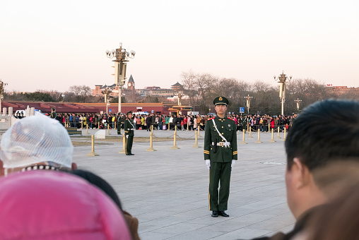Beijing, China - March 13, 2017 - A member of the Chinese People’s Liberation Army stands guard during the sunset flag-lowering ceremony in Tiananmen Square.
