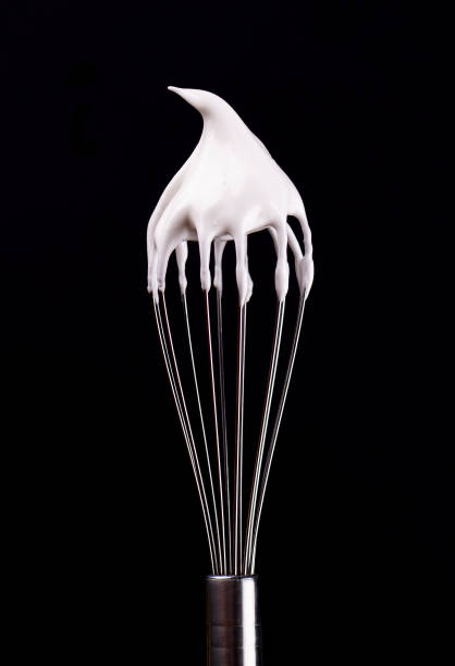 istock Metal whisk with whipped egg whites, isolated on black background. Clipping path. 1130580194