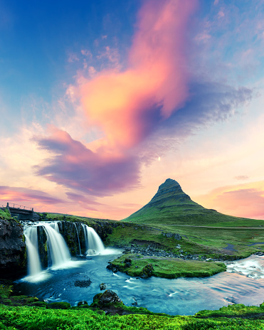 Colorful sunrise on Kirkjufellsfoss waterfall. Amazing morning scene near Kirkjufell volkano, Iceland