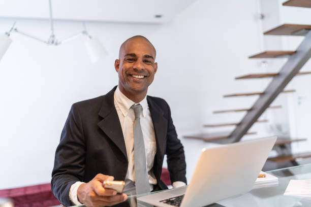 Afro latino businessman working on a laptop at home portrait Lifestyle of a businessman afro latinx ethnicity stock pictures, royalty-free photos & images