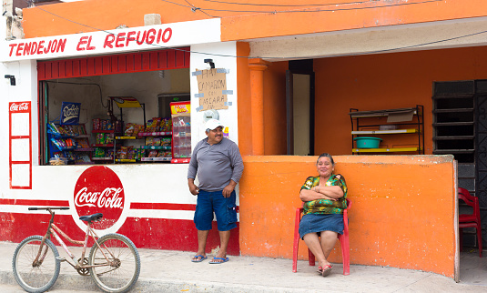 Celestún, Yucatan, Mexico: A senior couple sit outside their snack bar in Celestun, a beach village/tourist resort on the Gulf of Mexico about 60 miles from Merida, Yucatan Peninsula.